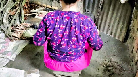 Asian woman in purple floral top and pink pants sitting from behind in homemade scene