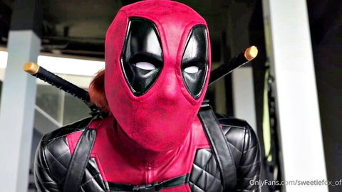 Curvy redhead in tight Deadpool cosplay posing seductively with katanas behind her head