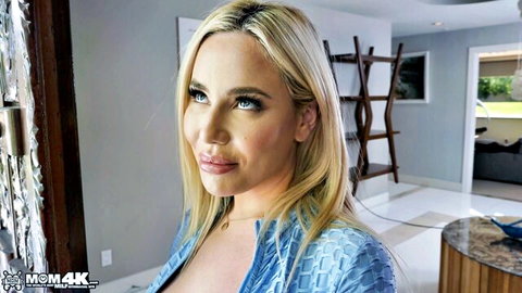 Blonde MILF Savannah Bond in low-cut blue top showing deep cleavage