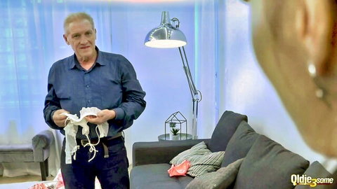 Older grandpa in blue shirt holding white fabric in steamy threesome preview