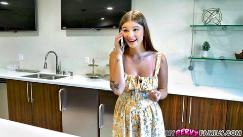 Busty blonde babe in low-cut floral sundress excitedly talking on phone showing deep cleavage
