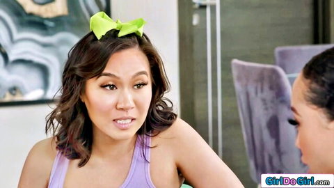 Asian stepdaughter with green bow in purple tank top chats intimately with Latina beauty in steamy lesbian preview