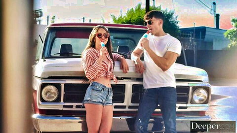 Skinny blonde babe in tiny denim shorts and open striped shirt licks ice cream with handsome guy by vintage red truck