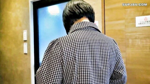 Woman in houndstooth coat stands at elevator door teasing viewers