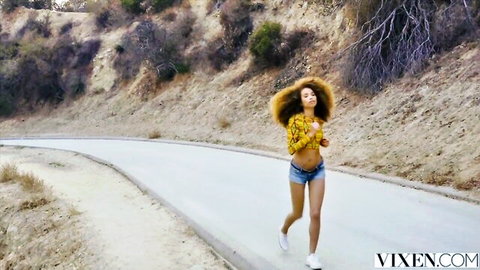 Sexy ebony teen jogging in yellow crop top and tiny denim shorts outdoors