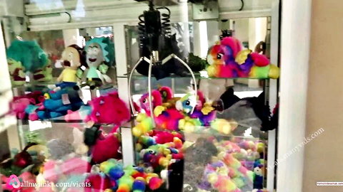 Claw machine packed with colorful stuffed unicorns, teddies and plush toys in arcade