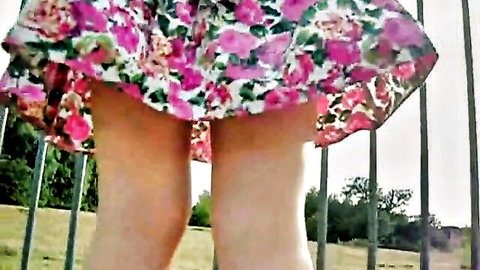 Pale babe lifts floral dress outdoors exposing shaved pussy and bare ass near fence