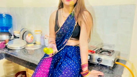 Skinny Indian babe in sheer blue saree teasing bare midriff holding lime in kitchen