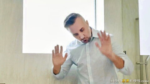 Man in white shirt gesturing with hands out in steamy Brazzers bathroom scene