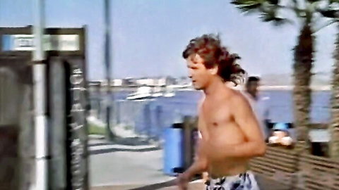 Shirtless retro hunk jogging waterfront in Justine film scene