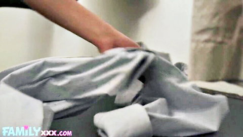Slim hand holds up gray sweatpants with thick cum stain on crotch in taboo scene