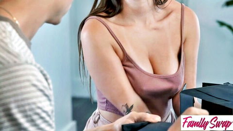 Busty brunette MILF in low-cut pink tank top flashes deep cleavage teasing man with black box in taboo Family Swap