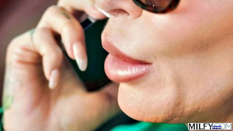 Tanned MILF in sunglasses puckers plump lips on phone teasing blowjob