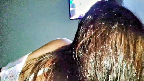 Brunette babe in tight white top side profile with tousled hair watching TV glow