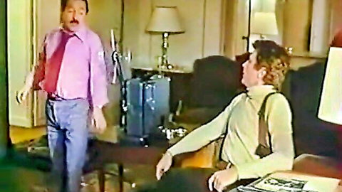 Two clothed men gesturing in vintage retro room with lamps and suitcase, no nudity