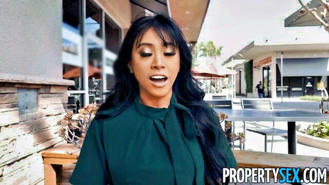 Sexy Asian babe in tight green top smiling outdoors at shopping plaza
