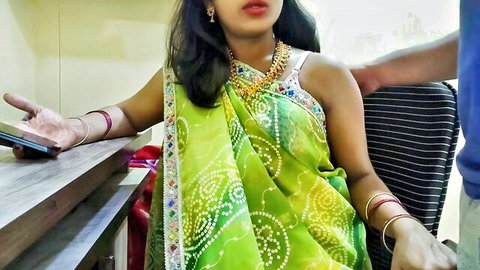 Busty Indian woman in sheer green saree with deep cleavage exposed as man's hand gropes her bare shoulder