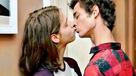 Long-haired woman passionately kissing curly-haired man in naughty couple embrace