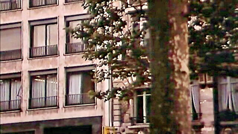 Vintage retro apartment building facade with balconies trees and urban exterior view