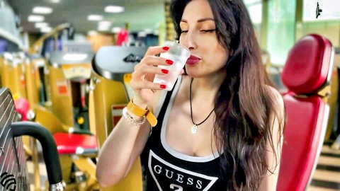 Busty brunette in low-cut GUESS tank top sips drink flashing huge cleavage in gym