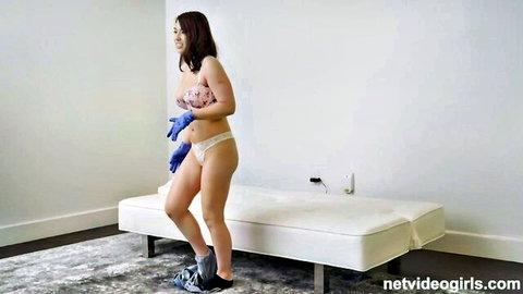 Busty Asian babe in lingerie and gloves teasing at casting couch