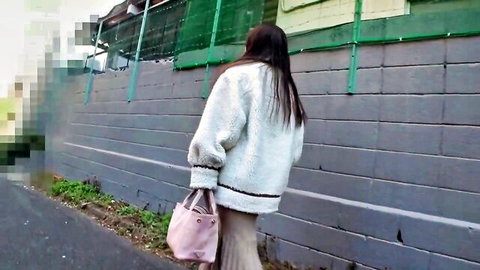 Asian babe with H-cup tits in fluffy jacket and pink skirt walks away outdoors