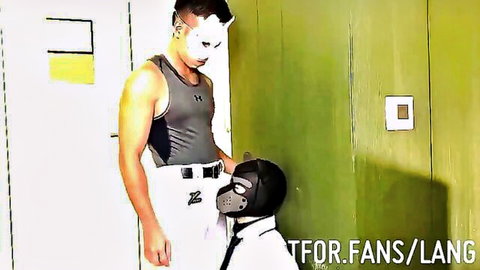 Chinese submissive man in mask kneels for dominant in office BDSM scene