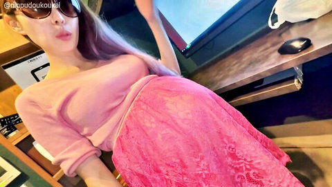 Pregnant Asian babe in pink lace skirt lifts hem showing huge round belly