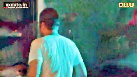 Indian man in wet see-through shirt viewed from behind in steamy room