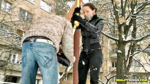 Brunette in leather jacket grips pole while guy bends over to eat her pussy outdoors in snow