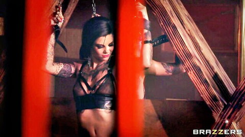 Bonnie Rotten in black lace lingerie, arms bound in chains, tattooed athletic body
