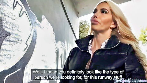 Sexy blonde MILF with huge lips in shiny black jacket teases at runway casting outdoors
