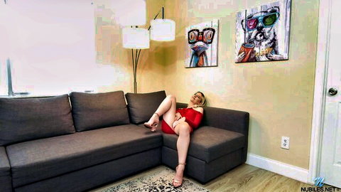 Jayden Black lounging seductively in red dress, legs up on couch