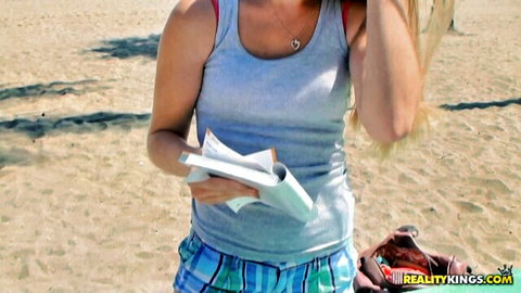 Petite blonde Olivia teases on beach in blue tank top and plaid shorts