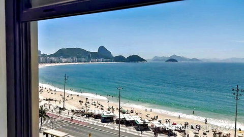 Scenic hotel window view of Copacabana beach and Sugarloaf Mountain in Rio