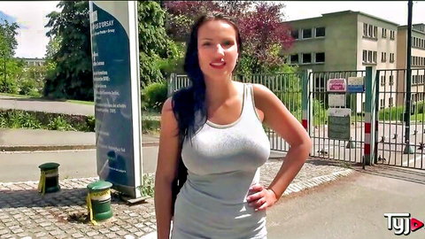 Sexy German bombshell in tight grey tank top posing outdoors, big cleavage