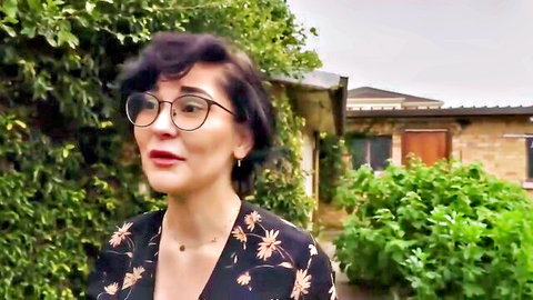 Sexy brunette teen in glasses and floral dress smiling outdoors