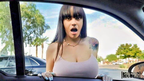 Melody Foxx leans out car window, shocked expression, deep cleavage in tank top