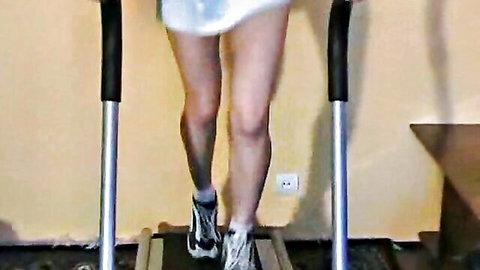 Stunning brunette babe jogging on treadmill in short white dress exposing ass