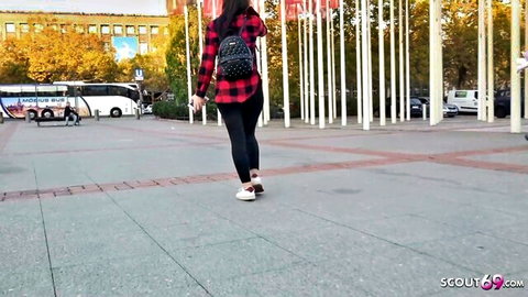 Casual woman in plaid shirt and leggings walking in urban square