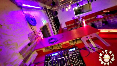 Neon-lit DJ booth with mixers and decks in vibrant club party setup
