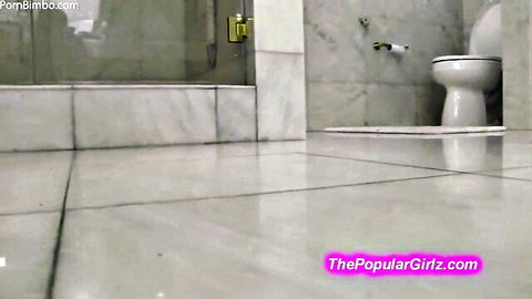 Empty luxury marble bathroom with white toilet and glass shower ready for femdom humiliation