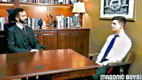 Suited bearded man interviews young twink in Masonic office scene