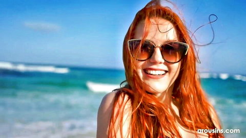 Charlie Red redhead smiling in sunglasses at beach
