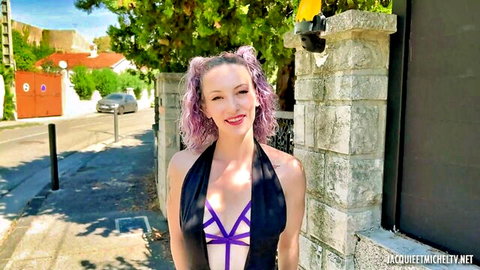Stella with purple pigtails smiling in revealing black harness lingerie