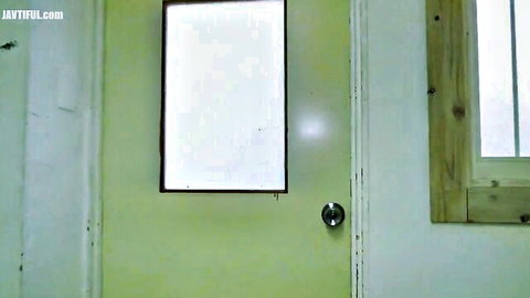 Green bathroom door with frosted window and wooden frame beside it