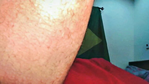 Closeup of hairy white arm in bathroom with green towel and red sheet