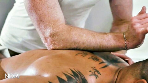Freckled white stud massages muscular tattooed ebony guy's oiled ass in gay interracial scene