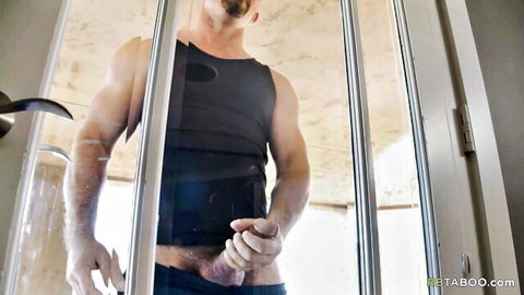 Muscular fair-skinned stud with goatee pulls down shorts exposing his thick hard cock