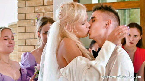 Blonde bride in veil passionately kissing groom at wedding while shocked bridesmaids watch